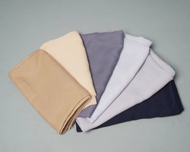 Gri arkaplana düzgünce yerleştirilmiş çıplak renkli peçeler. Müslüman kadınlar için kullanılmaya hazır gri renkli ince kumaş karışımı. Satış gösterileri için de kullanılabilir. Odak bulanıklığı. tesettür.