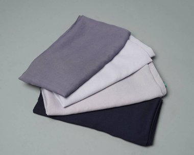 Gri arkaplana düzgünce yerleştirilmiş çıplak renkli peçeler. Müslüman kadınlar için kullanılmaya hazır gri renkli ince kumaş karışımı. Satış gösterileri için de kullanılabilir. Odak bulanıklığı. tesettür.