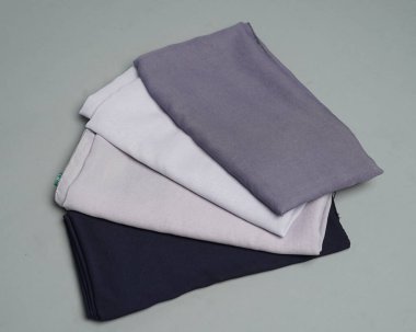 Gri arkaplana düzgünce yerleştirilmiş çıplak renkli peçeler. Müslüman kadınlar için kullanılmaya hazır gri renkli ince kumaş karışımı. Satış gösterileri için de kullanılabilir. Odak bulanıklığı. tesettür.