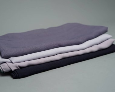 Gri arkaplana düzgünce yerleştirilmiş çıplak renkli peçeler. Müslüman kadınlar için kullanılmaya hazır gri renkli ince kumaş karışımı. Satış gösterileri için de kullanılabilir. Odak bulanıklığı. tesettür.