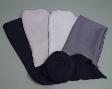 Gri arkaplana düzgünce yerleştirilmiş çıplak renkli peçeler. Müslüman kadınlar için kullanılmaya hazır gri renkli ince kumaş karışımı. Satış gösterileri için de kullanılabilir. Odak bulanıklığı. tesettür.