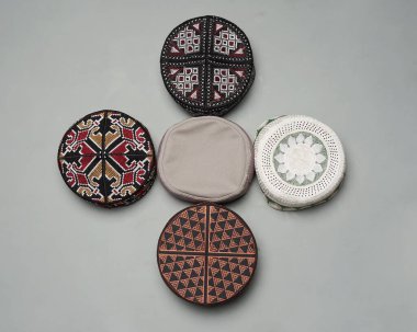 Değişik renk ve şekil motifleri olan kopya şapkası ya da peki koleksiyonu. Camiye dua ederken genellikle Müslüman erkekler için kullanılan Peci. İslami başlık beyaz arka planda izole edilmiş. Ied mubarok.