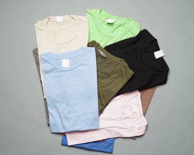 Düzgünce düzenlenmiş düz pamuklu tişörtler. Düz renkli tişörtler, tasarım modellerine dönüştürülmeye hazır. Tişörtler damgalanmadan temizdir. Erkeklerin boş tişört şablonu. Odak bulanıklığı. Kurban Mübarek