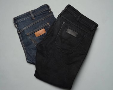 Düzgün düzenlenmiş mavi ve siyah kotlar. Çağdaş pantolonlar genellikle günümüz insanları için moda seçimi olarak kullanılır. Kotlar dayanıklıdır ve kolayca zarar görmez. dizayn şablonları için uzun pantolon modeli.