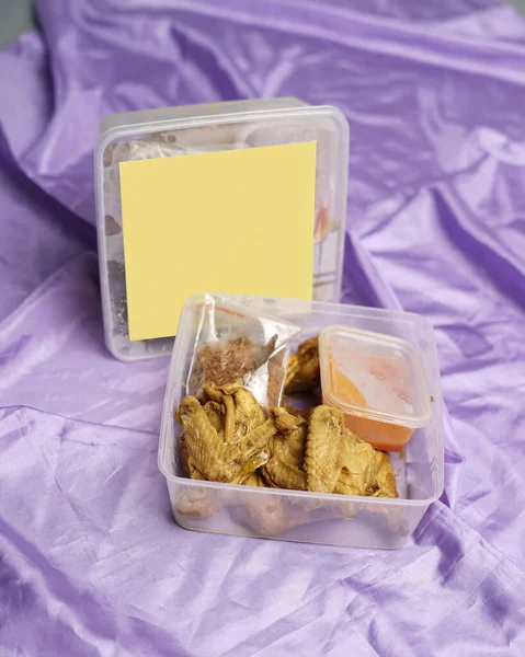Chicken wrapped with Indonesian spices. Chicken pieces are ready to be fried. Ready-to-eat food in box packaging complete with chili sauce etc. Food packaging mockup box for template. Focus blur.