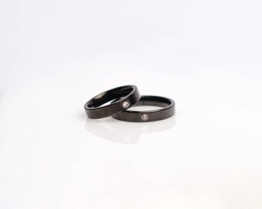 Elmaslı mücevher yüzüğü. Derin bir anlamı ve anlamı olan alyanslar. Mücevher taşlı nişan yüzüğü. Evlilik yüzüğü beyaz arka planda izole edilmiş, bulanık odaklı. Bir çift altın, gümüş, siyah.