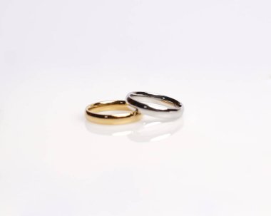 Elmaslı mücevher yüzüğü. Derin bir anlamı ve anlamı olan alyanslar. Mücevher taşlı nişan yüzüğü. Evlilik yüzüğü beyaz arka planda izole edilmiş, bulanık odaklı. Bir çift altın, gümüş, siyah.