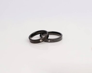 Elmaslı mücevher yüzüğü. Derin bir anlamı ve anlamı olan alyanslar. Mücevher taşlı nişan yüzüğü. Evlilik yüzüğü beyaz arka planda izole edilmiş, bulanık odaklı. Bir çift altın, gümüş, siyah.