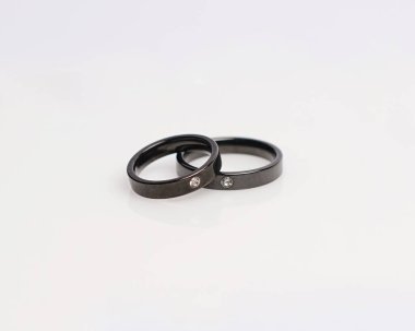 Elmaslı mücevher yüzüğü. Derin bir anlamı ve anlamı olan alyanslar. Mücevher taşlı nişan yüzüğü. Evlilik yüzüğü beyaz arka planda izole edilmiş, bulanık odaklı. Bir çift altın, gümüş, siyah.