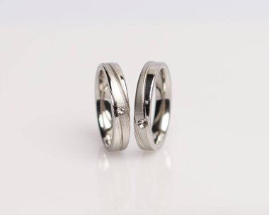 Elmaslı mücevher yüzüğü. Derin bir anlamı ve anlamı olan alyanslar. Mücevher taşlı nişan yüzüğü. Evlilik yüzüğü beyaz arka planda izole edilmiş, bulanık odaklı. Bir çift altın, gümüş, siyah.