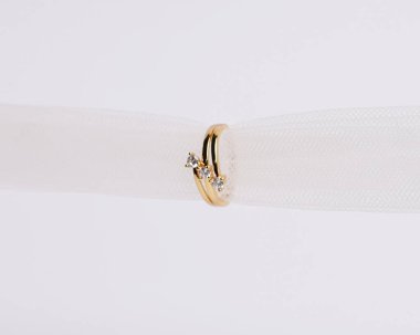 Mücevher yüzüğünün kumaş rulosuna yerleştirilmiş konsept fotoğrafı. Derin bir anlamı ve anlamı olan alyanslar. Mücevher ya da elmaslı nişan yüzüğü. Alyans beyaz arkaplanda izole edildi.