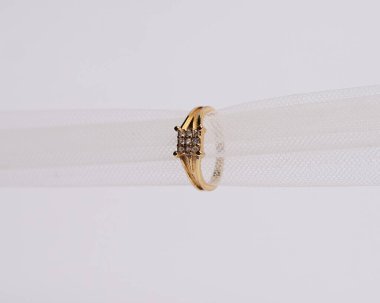 Mücevher yüzüğünün kumaş rulosuna yerleştirilmiş konsept fotoğrafı. Derin bir anlamı ve anlamı olan alyanslar. Mücevher ya da elmaslı nişan yüzüğü. Alyans beyaz arkaplanda izole edildi.