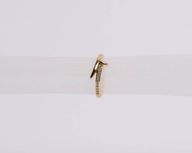 Mücevher yüzüğünün kumaş rulosuna yerleştirilmiş konsept fotoğrafı. Derin bir anlamı ve anlamı olan alyanslar. Mücevher ya da elmaslı nişan yüzüğü. Alyans beyaz arkaplanda izole edildi.