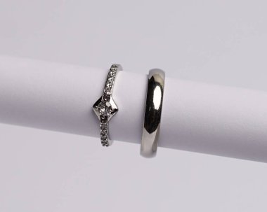 Mücevher yüzüğünün kumaş rulosuna yerleştirilmiş konsept fotoğrafı. Derin bir anlamı ve anlamı olan alyanslar. Mücevher ya da elmaslı nişan yüzüğü. Alyans beyaz arkaplanda izole edildi.