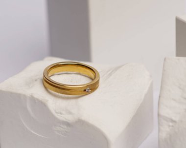 Alyans beyaz taşa takılmış. Mücevher yüzüğü sergilenip satılmaya hazır. Alyans, bu çiftin aşkının bir işareti. İnciler ve elmaslar yüzüğün güzelliğini tamamlıyor. odak bulanıklığı.