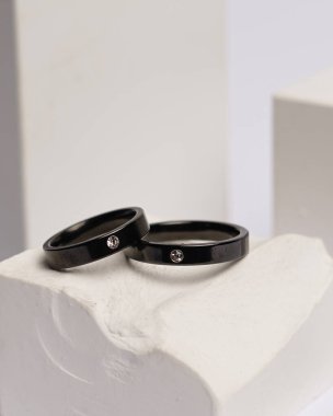 Alyans beyaz taşa takılmış. Mücevher yüzüğü sergilenip satılmaya hazır. Alyans, bu çiftin aşkının bir işareti. İnciler ve elmaslar yüzüğün güzelliğini tamamlıyor. odak bulanıklığı.