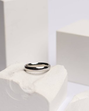 Alyans beyaz taşa takılmış. Mücevher yüzüğü sergilenip satılmaya hazır. Alyans, bu çiftin aşkının bir işareti. İnciler ve elmaslar yüzüğün güzelliğini tamamlıyor. odak bulanıklığı.