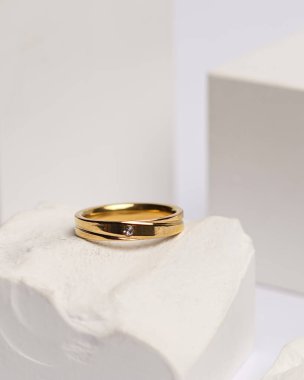 Alyans beyaz taşa takılmış. Mücevher yüzüğü sergilenip satılmaya hazır. Alyans, bu çiftin aşkının bir işareti. İnciler ve elmaslar yüzüğün güzelliğini tamamlıyor. odak bulanıklığı.