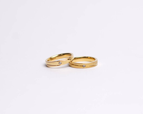 Jewelery ring with diamonds. Wedding rings that have deep meaning and significance. Engagement ring with gemstones. Wedding ring isolated on white background, focus blur. Pair in gold, silver, black.