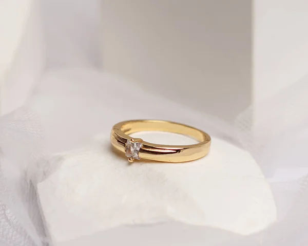 Wedding ring set on white stone. The jewelry ring is ready to be showcased and sold. The wedding ring is a sign of the love of the couple. Pearls and diamonds complete the ring\'s beauty. focus blur.