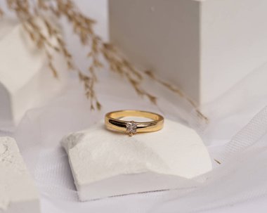 Alyans beyaz taşa takılmış. Mücevher yüzüğü sergilenip satılmaya hazır. Alyans, bu çiftin aşkının bir işareti. İnciler ve elmaslar yüzüğün güzelliğini tamamlıyor. odak bulanıklığı.