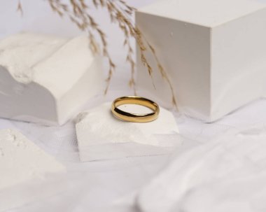 Alyans beyaz taşa takılmış. Mücevher yüzüğü sergilenip satılmaya hazır. Alyans, bu çiftin aşkının bir işareti. İnciler ve elmaslar yüzüğün güzelliğini tamamlıyor. odak bulanıklığı.