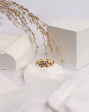 Alyans beyaz taşa takılmış. Mücevher yüzüğü sergilenip satılmaya hazır. Alyans, bu çiftin aşkının bir işareti. İnciler ve elmaslar yüzüğün güzelliğini tamamlıyor. odak bulanıklığı.