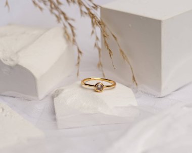 Alyans beyaz taşa takılmış. Mücevher yüzüğü sergilenip satılmaya hazır. Alyans, bu çiftin aşkının bir işareti. İnciler ve elmaslar yüzüğün güzelliğini tamamlıyor. odak bulanıklığı.