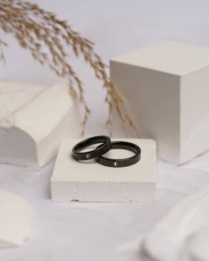 Alyans beyaz taşa takılmış. Mücevher yüzüğü sergilenip satılmaya hazır. Alyans, bu çiftin aşkının bir işareti. İnciler ve elmaslar yüzüğün güzelliğini tamamlıyor. odak bulanıklığı.