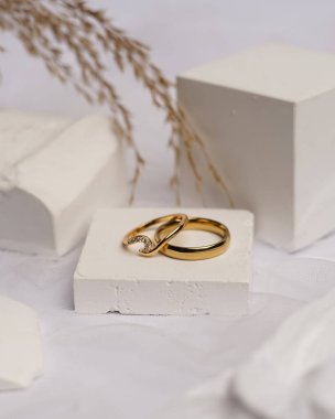 Alyans beyaz taşa takılmış. Mücevher yüzüğü sergilenip satılmaya hazır. Alyans, bu çiftin aşkının bir işareti. İnciler ve elmaslar yüzüğün güzelliğini tamamlıyor. odak bulanıklığı.