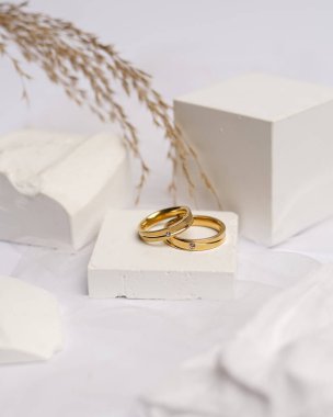 Alyans beyaz taşa takılmış. Mücevher yüzüğü sergilenip satılmaya hazır. Alyans, bu çiftin aşkının bir işareti. İnciler ve elmaslar yüzüğün güzelliğini tamamlıyor. odak bulanıklığı.