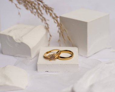 Alyans beyaz taşa takılmış. Mücevher yüzüğü sergilenip satılmaya hazır. Alyans, bu çiftin aşkının bir işareti. İnciler ve elmaslar yüzüğün güzelliğini tamamlıyor. odak bulanıklığı.