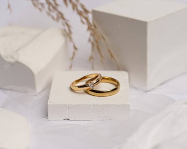 Alyans beyaz taşa takılmış. Mücevher yüzüğü sergilenip satılmaya hazır. Alyans, bu çiftin aşkının bir işareti. İnciler ve elmaslar yüzüğün güzelliğini tamamlıyor. odak bulanıklığı.