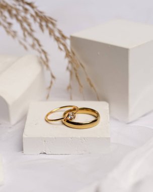 Alyans beyaz taşa takılmış. Mücevher yüzüğü sergilenip satılmaya hazır. Alyans, bu çiftin aşkının bir işareti. İnciler ve elmaslar yüzüğün güzelliğini tamamlıyor. odak bulanıklığı.