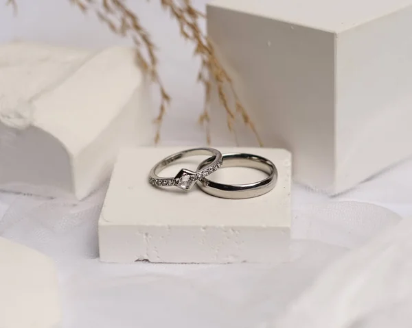 Wedding ring set on white stone. The jewelry ring is ready to be showcased and sold. The wedding ring is a sign of the love of the couple. Pearls and diamonds complete the ring\'s beauty. focus blur.