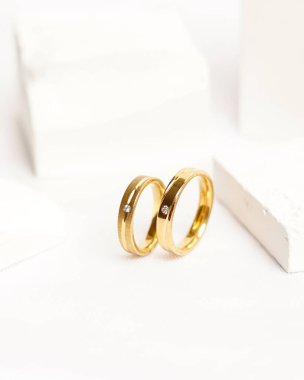 Sosyal medya gösterisi için elmas mücevher yüzüğü. Alyans beyaz taşın üzerinde fotoğraflandı. Mücevher taşlı nişan yüzüğü. Alyanslar parlak beyaz bir arkaplanda izole edilmiş, bulanık odaklı. Altın yüzük..