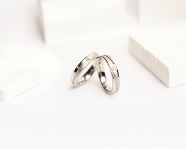 Sosyal medya gösterisi için elmas mücevher yüzüğü. Alyans beyaz taşın üzerinde fotoğraflandı. Mücevher taşlı nişan yüzüğü. Alyanslar parlak beyaz bir arkaplanda izole edilmiş, bulanık odaklı. Altın yüzük..