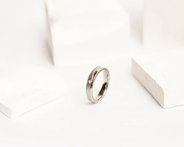用于社交媒体展示的钻石戒指 婚戒在白石上拍照 订婚戒指上有宝石 结婚戒指孤立在明亮的白色背景上 焦点模糊不清 金戒指 — 图库照片