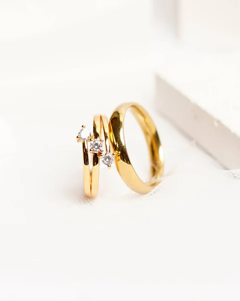 ソーシャルメディアディスプレイ用ダイヤモンドジュエリーリング 結婚指輪は白い石の上で撮影した 宝石との婚約指輪 結婚指輪は明るい白の背景に隔離され 焦点をぼかす ゴールドリング — ストック写真