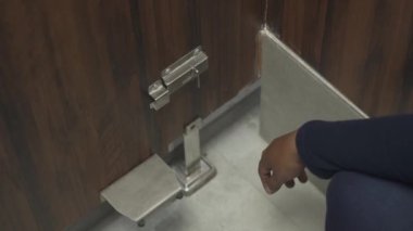 Aşağıdaki kapının kilidini açma sürecinin video görüntüleri. Direkt teması azaltmak için ayakları kullanma süreci. Banyo ahşap kapı kilidi. odak bulanıklığı