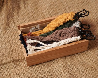 Makrame anahtarlık, Macrame shot, evde kadınlar tarafından el yapımı. Makrome ve el sanatları afişleri ve reklamlar için harika DIY görüntüleri. Aksesuarlı yaratıcı hobi düzeni, üst görünüm. El yapımı makrome..