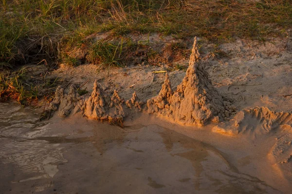 Песчаный Замок Пляже Возле Воды Освещается Закатом — стоковое фото