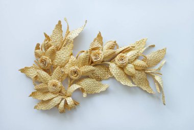 Yapraklı dal samandan yapılmıştır. Beyaz arka planda saman süslemesi. Alanın küçük derinliği