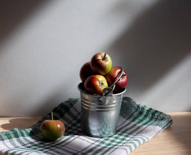 Ahşap bir masada elma dolu bir kova