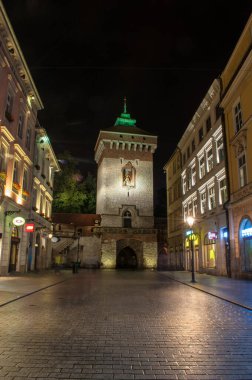 Krakow, Polonya - 18 Temmuz 2016: Eski kentin ana caddelerinden biri kaldırımda yanan binalar ve yansımalarla ana meydana çıkıyor