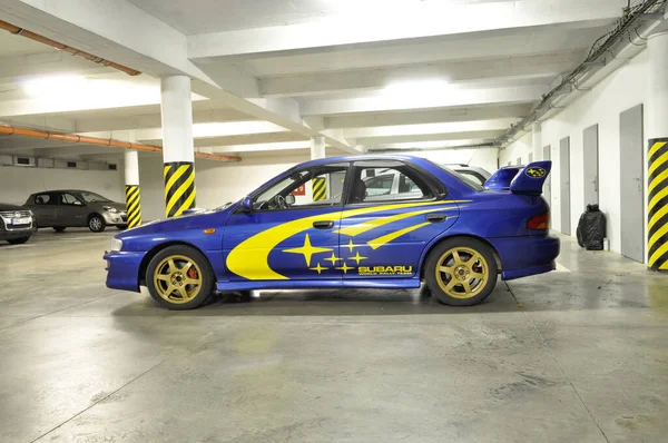 Brno, Çek Cumhuriyeti - 05 Ekim 2018: Mavi Subaru Impreza hangi garajda duruyor ve folyoya sarı çıkartmalar yapıştırıyor