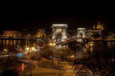 Budapeşte, Macaristan - 09 Ekim 2012: Budapeşte 'deki eski ışınlanmış Zincir Köprüsü' nün gece görüşü Tuna Nehri 'ne yansıdı. Arka planda şehrin tarihi evlerini görebilirsiniz..
