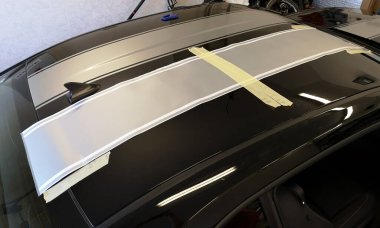 Siyah hızlı spor spor kaslı bir arabanın üzerine gümüş folyo çıkartması yerleştirildi.