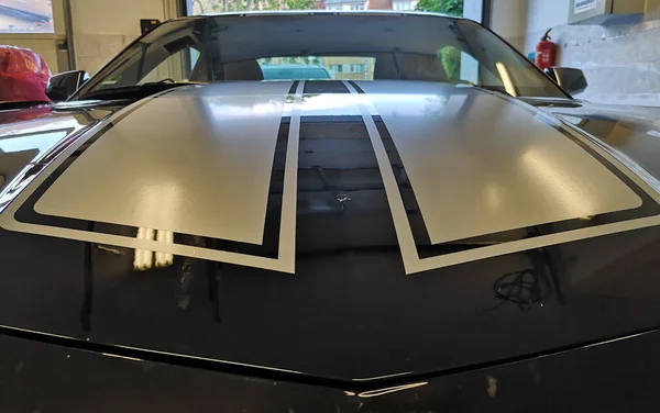 Installation Von Silbernen Folienabziehbildern Auf Einem Schwarzen Schnellen Muscle Car — Stockfoto