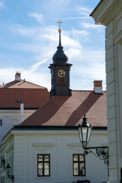 城の屋根の上に黄金の時計と教会の塔 前景には家の壁と古い金属製の提灯 — ストック写真